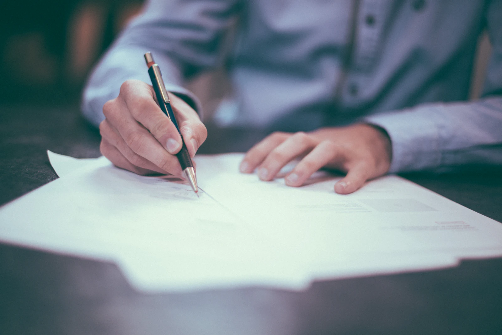 A hand with a pen examining a printed business document